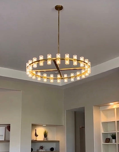 The rhythmic design of this chandelier collection is inspired by the shape and scale of industrial gears, where spokes are interlaced with negative space to interlock with other gears. Here, the spokes are hexagonal in form, juxtaposed with a circular interior, crafted from crystal glass, running along a simple, sturdy metal frame. The light shines through the glass as if it were a candle.
